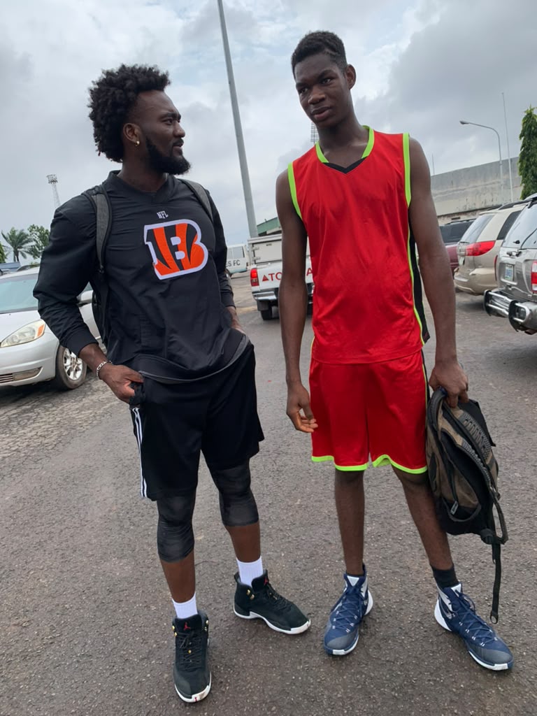 Eric Okenchi talking with a young player in a red jersey